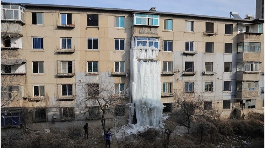 遼寧一棟待拆的公寓因為水管漏水加上外面零下20度低溫，屋外凍出一道冰瀑布。(圖／翻攝自陸網)