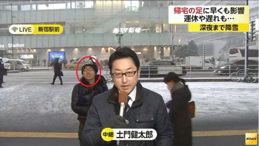 日本媒體進行SNG連線時，有男子見鏡頭往阿拍攝，他人就出現在那裡。(圖／翻攝自富士電視網)