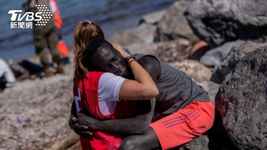 抵達西班牙領地「休達」（Ceuta）的一位非洲移民，情緒激動地抱住西班牙紅十字會的工作人員。（圖／達志影像美聯社）
