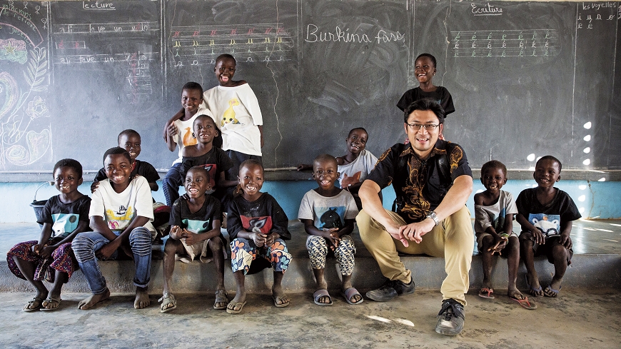 連加恩（右3）回到2004年創辦的孤兒院「霖恩小學」， 親切與孩子們互動。