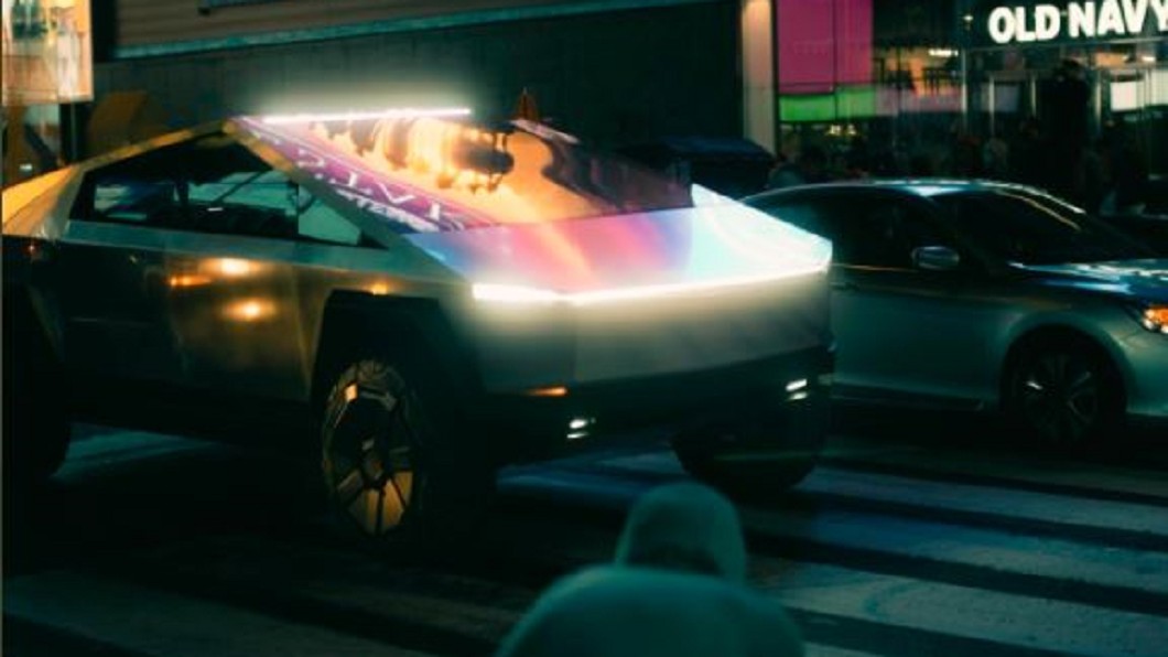 Cybertruck不銹鋼材質車身在LED廣告看板下反光出不同車色。(圖片截自推特)