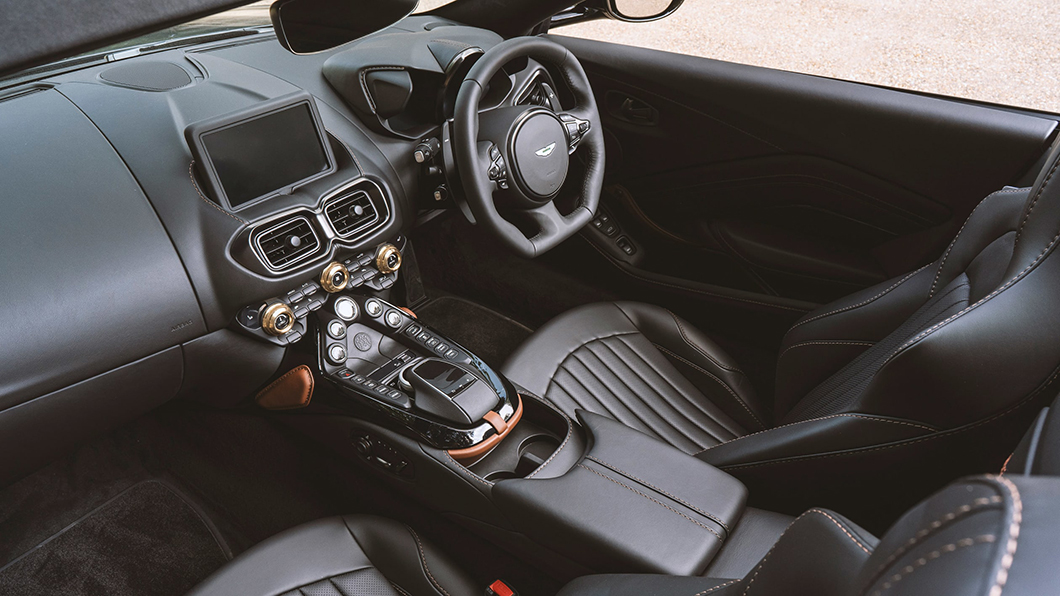 座艙內曜石黑皮栗棕褐皮革搭配，中控旋鈕配置典雅的古銅色元素及專屬Aston Martin傳統字樣銘牌。（圖片來源/ Aston Martin ）