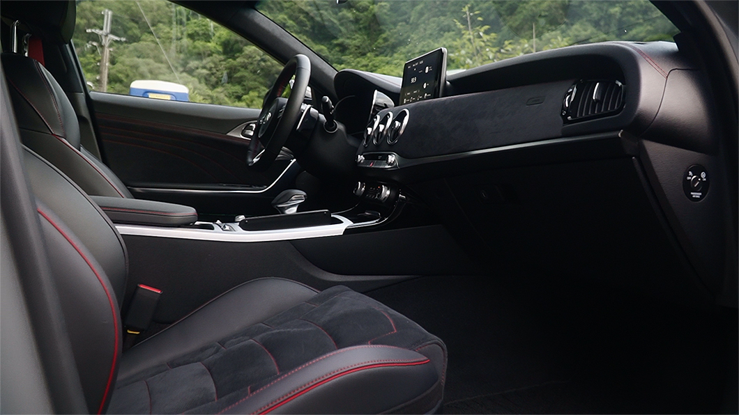 車內透過黑色麂皮與皮革搭配紅色縫線，營造不俗的競技感。(圖片來源/ TVBS)