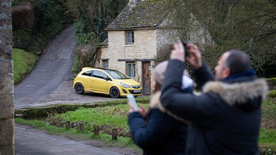 有一位遊客在Twitter上發文抱怨，村莊當中的黃色小車破壞了整張照片的風景。(圖片來源/ mail online)