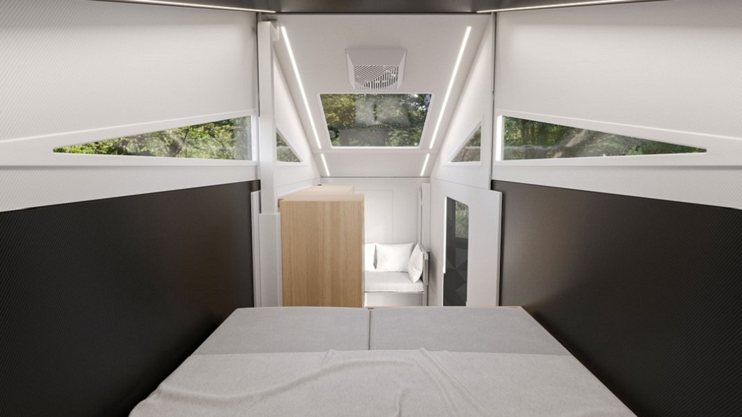床組設計在貨斗上方空間，並且向下延伸起居室與廚房。(圖片來源/ Form Camper)