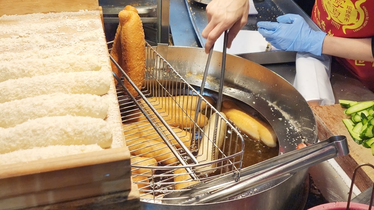 店家自製的手工麵包在油鍋裡炸至金黃酥香，趁熱享用最是過癮！（圖片來源：米寶麻幸福滿載）