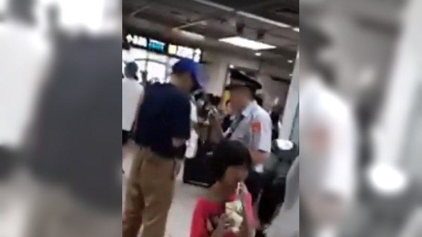 小女孩(紅衣)在捷運站喝飲料、吃冰，其父(藍衣者)怒罵保全員，警方到場處理。圖／截取自爆料公社