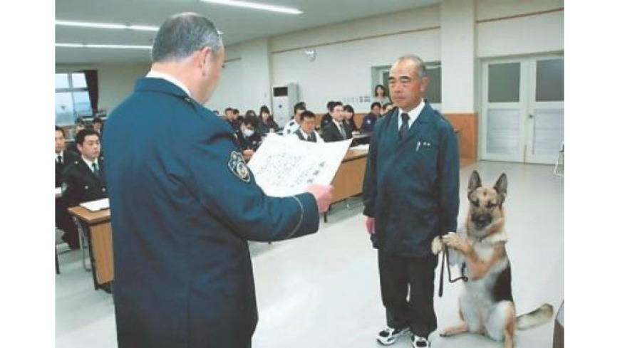 日本一隻警犬在台上接受表揚時，疑似因為太過緊張，2隻前腳抬起，抓住員警的手腕，可愛模樣讓網友笑翻，也吸引網友轉貼分享。