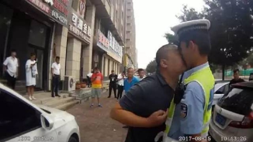 一名壯漢因不滿交警開單取締，直接把臉貼上去親吻對方。(圖／翻攝自海峽吧)