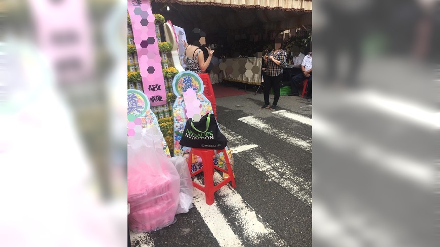 這2位女生在別人告別式的罐頭塔前拍照，引發網友抨擊。(圖／翻攝自爆料公社臉書粉絲團)