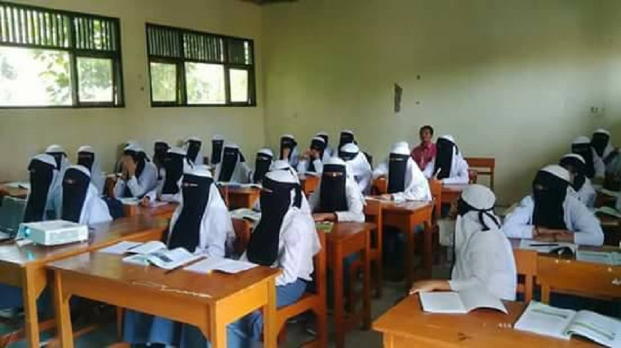 印尼一所高中要求女學生得戴全罩式面紗上課，校方稱說是避免學生濫交。(圖／翻攝自臉書)
