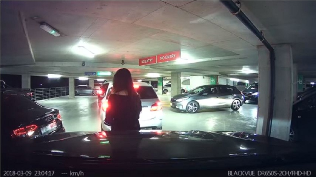 有網友在澳洲雪梨看完張學友的演唱會準備開車離開時，一名長髮女子擋在他車前不讓他開出來。(圖／翻攝自YouTube) 長髮女「肉身擋車」助友插隊　駕駛譙：別給華人丟臉