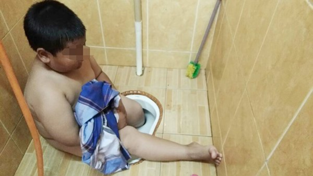 馬來西亞一名胖童，不慎一腳踩入馬桶洞中，動彈不得。圖／翻攝自中國報