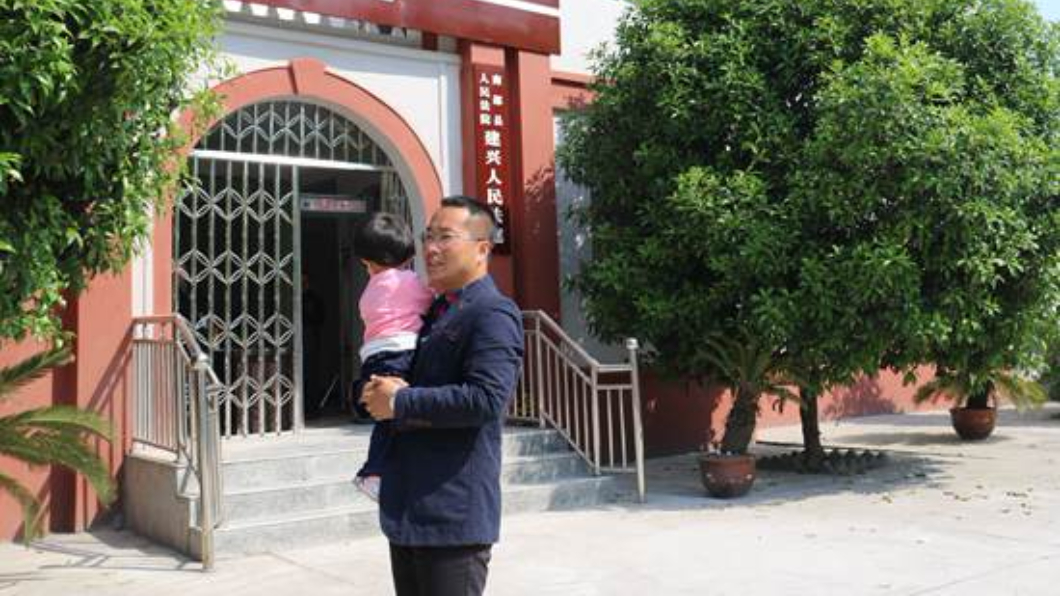 庭長抱著遭楊男遺棄的女兒。圖/翻攝自四川新聞網