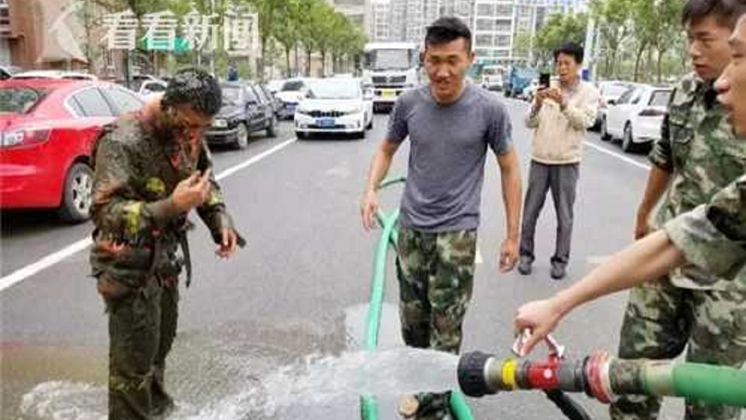 翁姓消防員上來後,夥伴連忙用清水幫他清洗身體。(圖/翻攝自看看新聞)