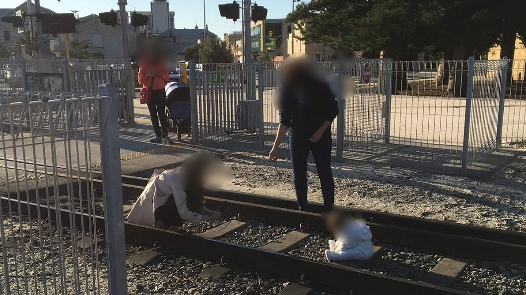 澳洲有一名母親把小嬰兒放在鐵軌上，自己卻在一旁自拍，引發網友強烈抨擊。(圖／翻攝自推特)