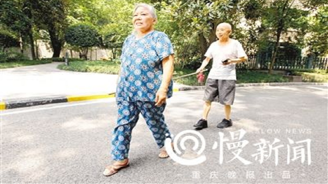大陸四川一對夫妻，妻子每天都會用竹竿牽著失明的丈夫散步。(圖／翻攝自陸網)