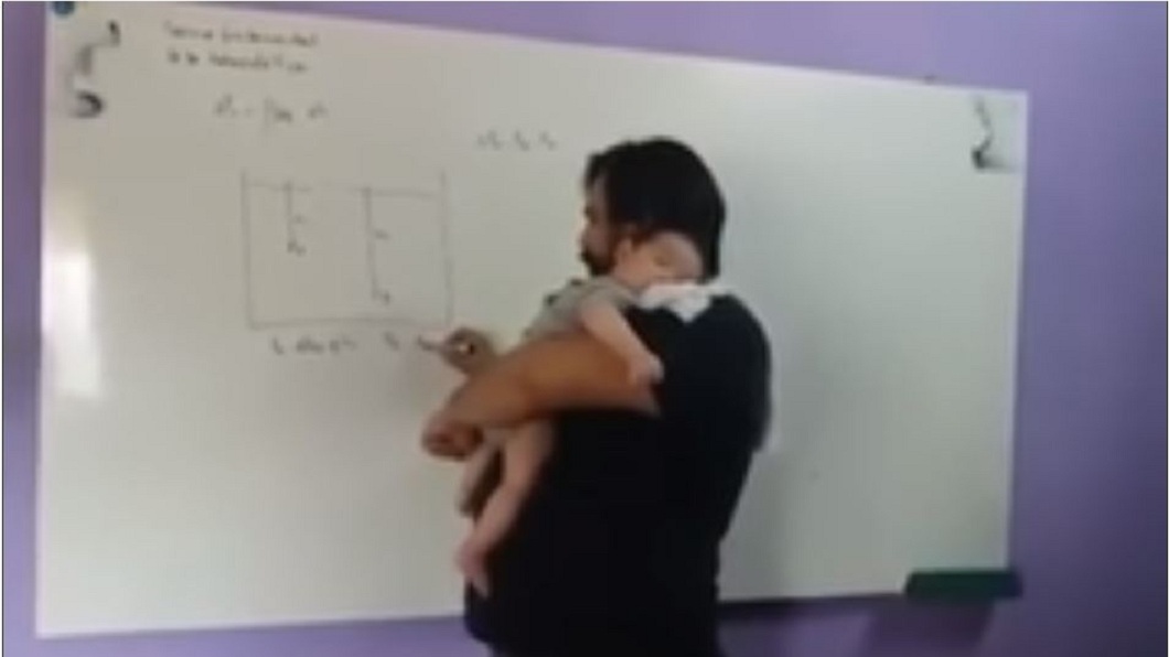 巴拉圭一名人父邊抱著兒子邊授課，這充滿父愛的一面被學生們拍了下來。(圖／翻攝自YouTube)