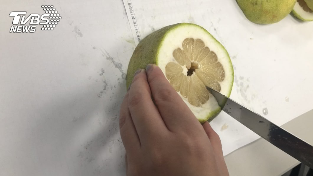 剖半的柚子,各在側邊切上一刀