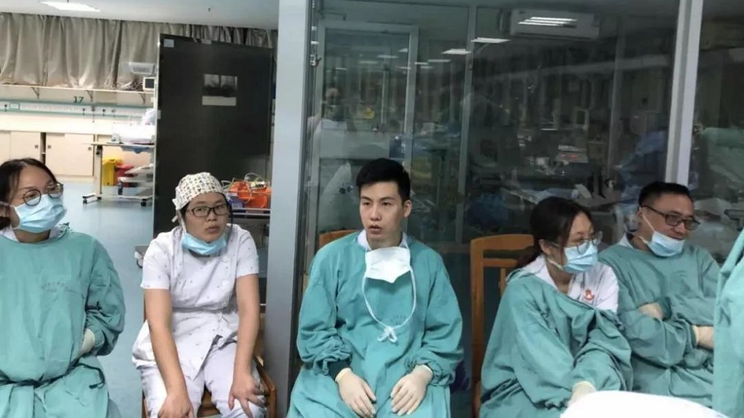 30多名醫護人員5小時內輪流幫小雨進行3萬次胸外心臟按壓,最後累倒在一旁休息。(圖/翻攝自微博)
