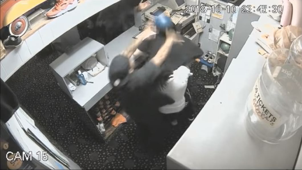 黑衣男更拿起保齡球朝店員的頭部砸過去。(圖/翻攝自YouTube)