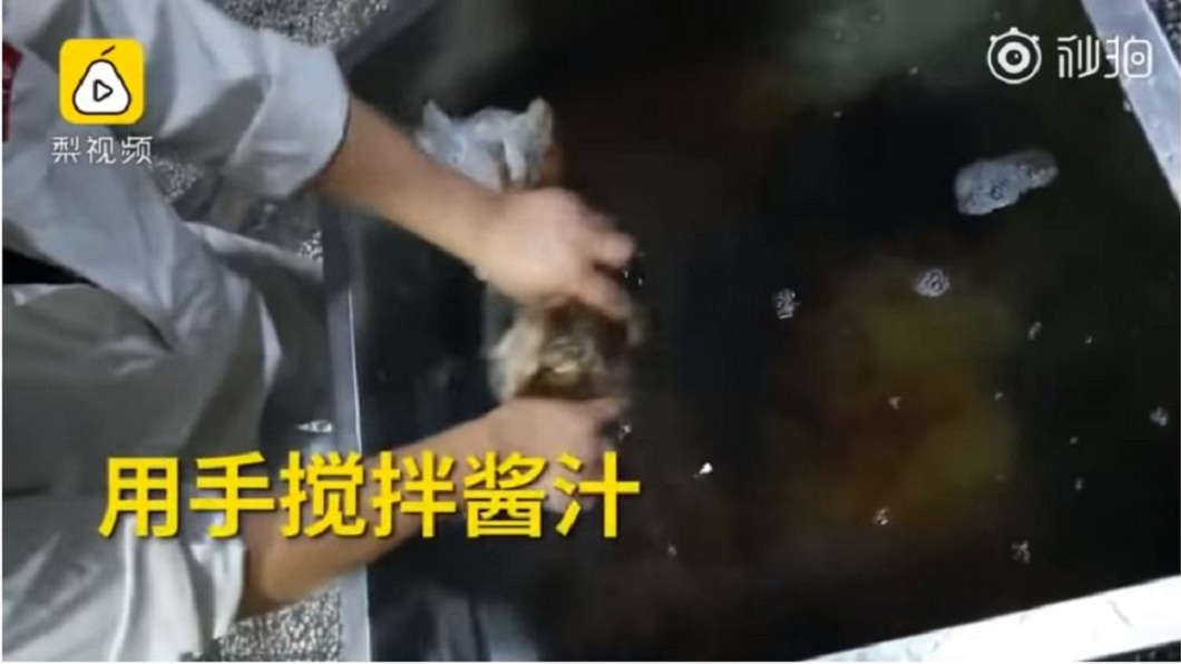 工作人員沒帶任何的手套或其他防護措施,直接用手抓肉去攪拌醬汁。(圖/翻攝自梨視頻)