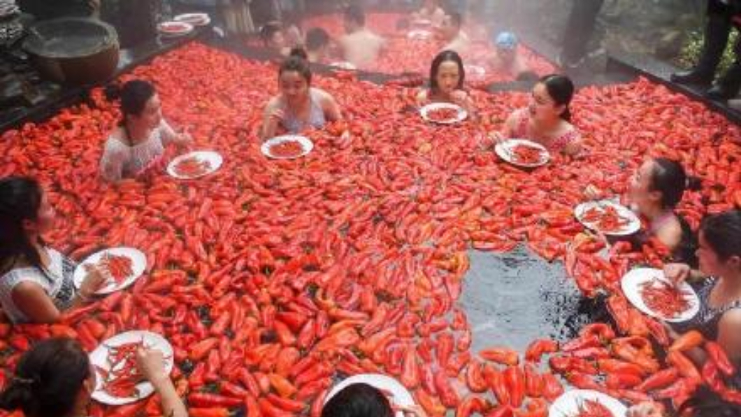 參賽者必須浸泡在充滿辣椒的溫泉中，比賽看誰吃完最多辣椒。圖／翻攝自《中國新聞網》