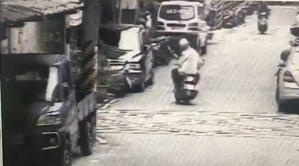游男騎車行經金門街215巷時,從包包掉出一疊鈔票,還回頭看了一眼。/警方提供