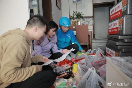 陸姓男子和女友與送貨員核對8箱零食。圖/翻攝自微博
