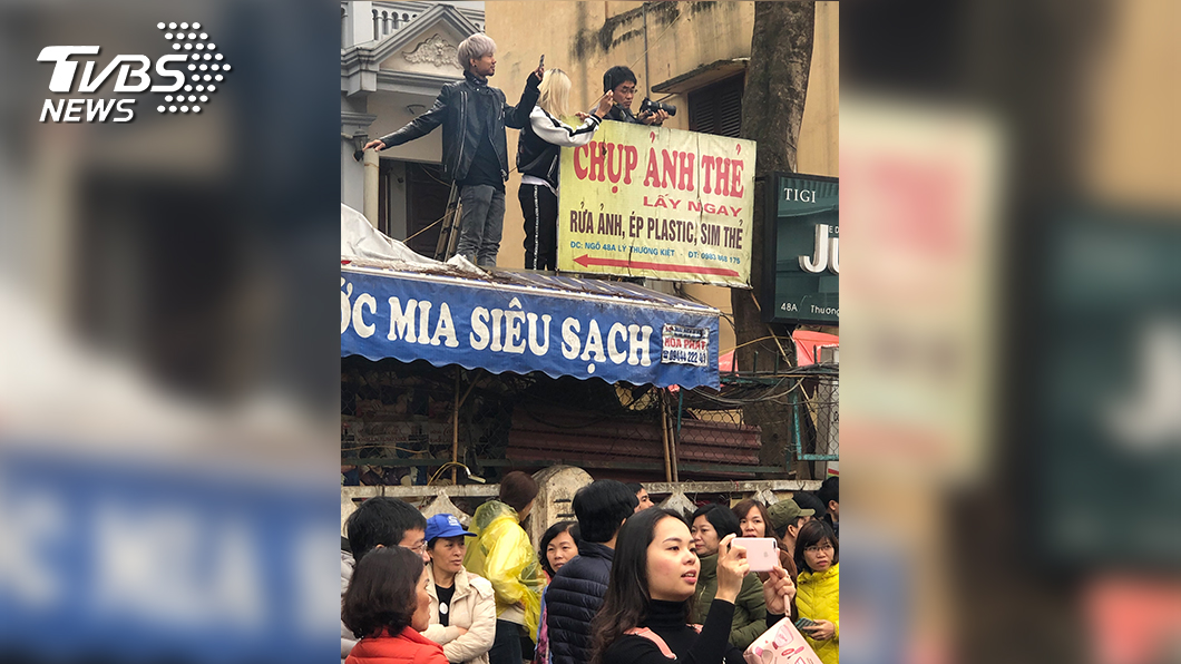 當地居民為了一睹這場國際盛事,不惜爬到屋簷上觀看和拍照。(圖/TVBS)