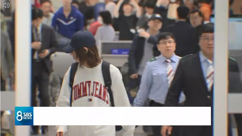 鄭俊英(左,白衣者)12日晚間返回韓國,將接受警方調查。圖/翻攝自SBS 8點新聞