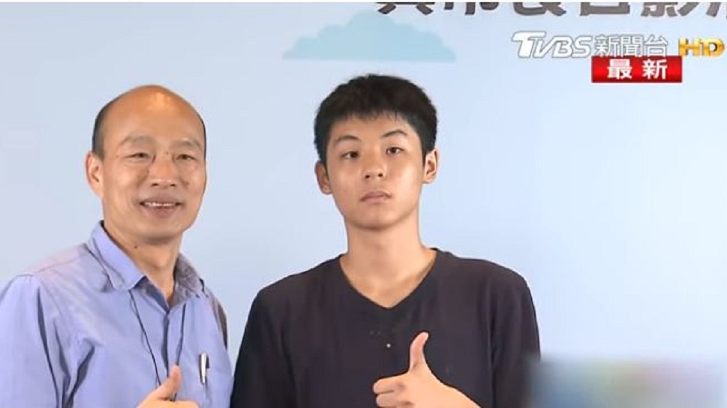 韓國瑜原本面露微笑地和男學生比讚合影。(圖/TVBS)