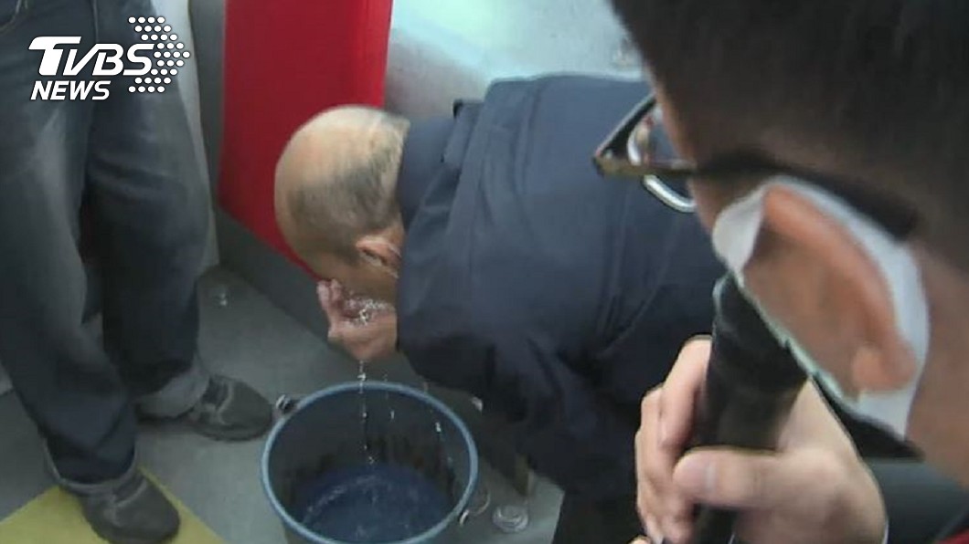 韓國瑜徒手撈起水桶裡的消毒水嗅一嗅。(圖／TVBS資料畫面)