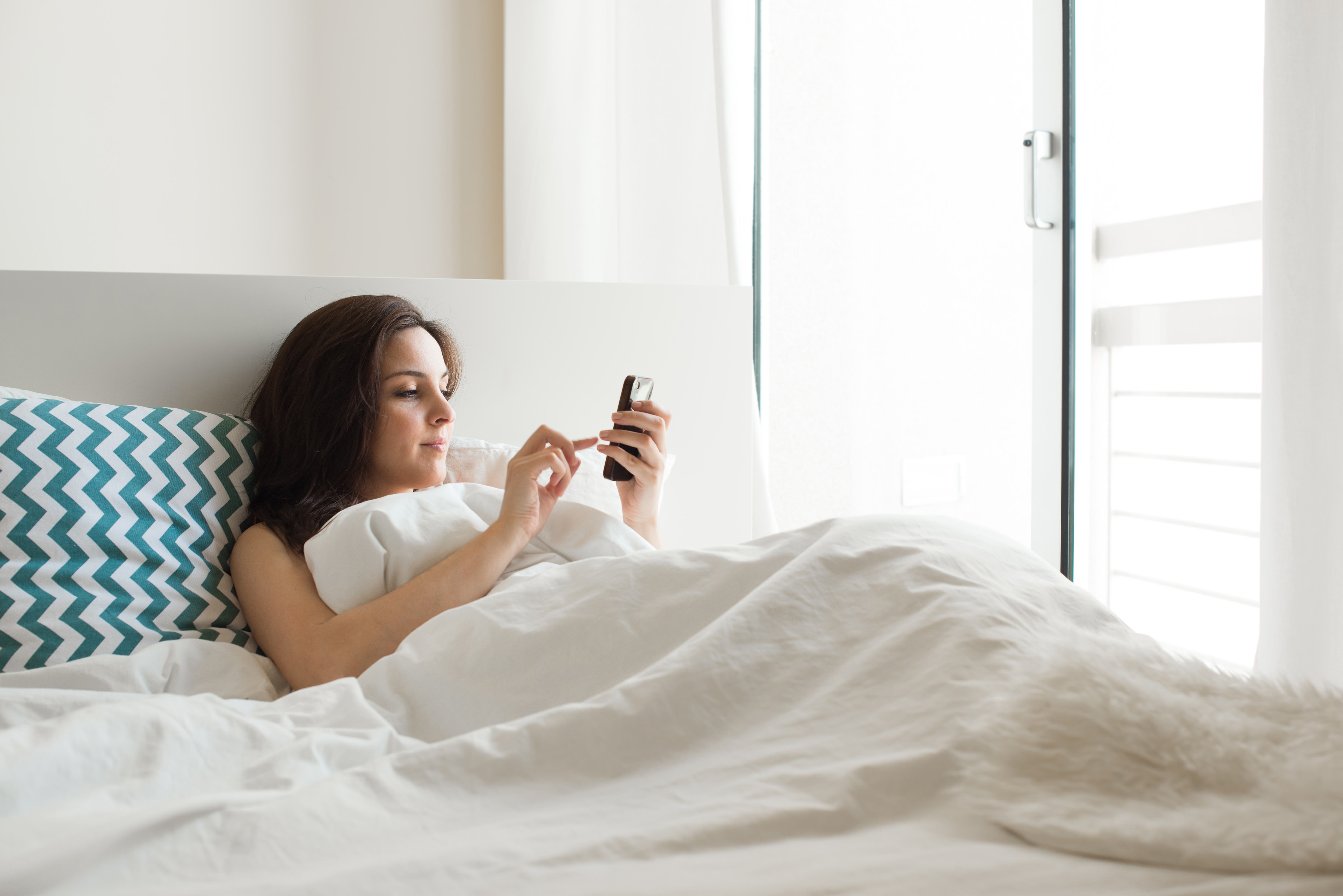 許多人喜歡躺在床上滑手機，但姿勢不正確恐導致腰痠背痛。(示意圖／TVBS)