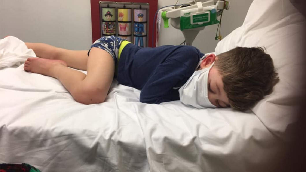 英國1名5歲男童確診新冠肺炎，虛弱無力地躺在病床上。(圖／翻攝自臉書)