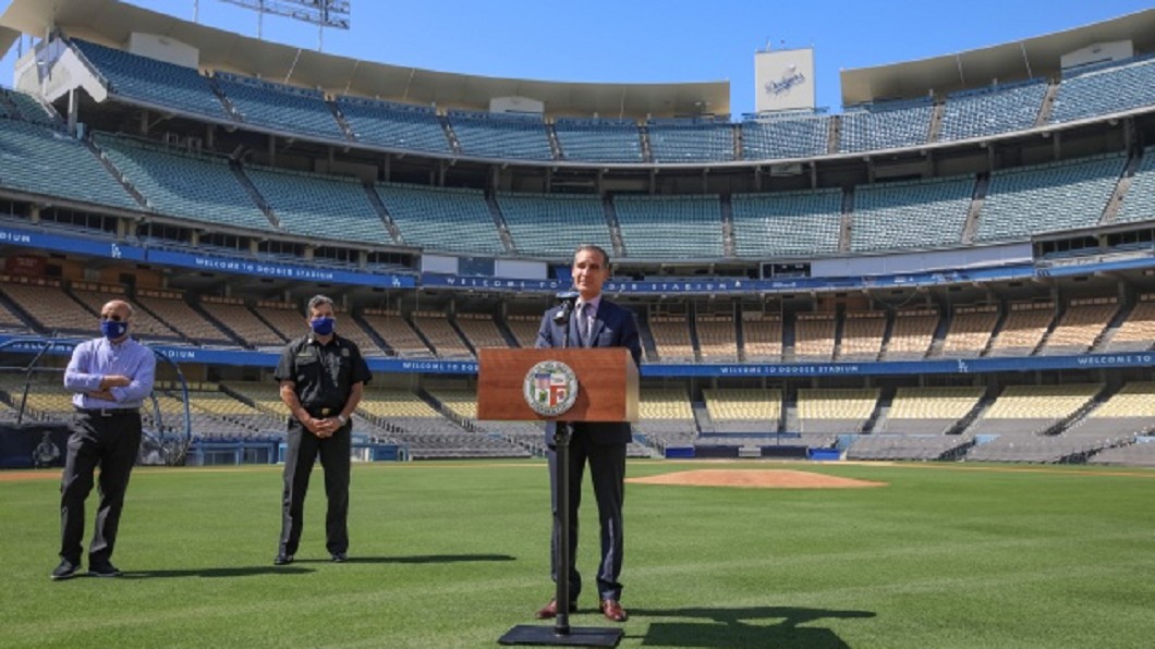 美國洛杉磯市長賈西迪（前）在洛杉磯道奇隊的棒球場草皮上，宣布設置在球場外停車場的篩檢站啟用。圖／中央社（市長辦公室提供）