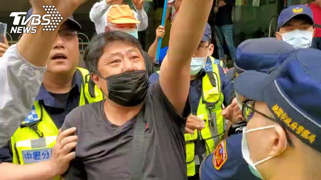 鋼鐵韓粉杏仁哥被警方帶離現場。（圖／TVBS）