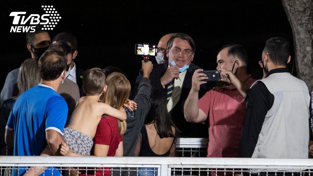巴西總統波索納洛脫下口罩和支持者玩自拍。（圖／達志影像美聯社）
