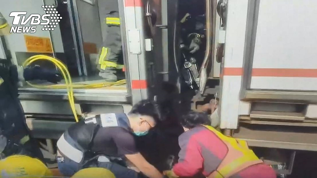 消防人員趕抵現場救出被夾在2列車廂中的林姓調車員。（圖／TVBS）