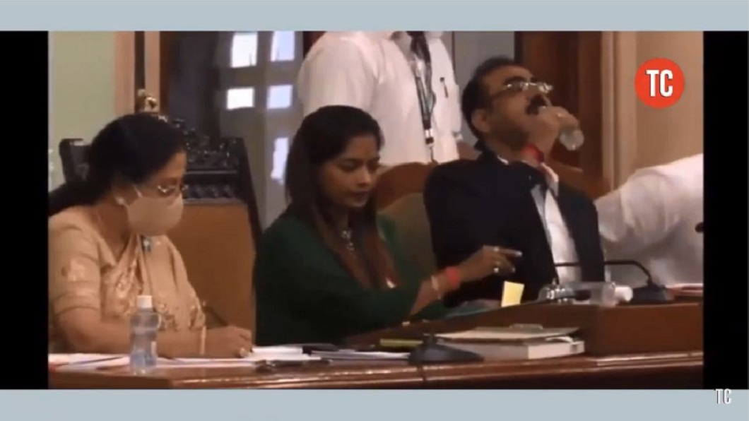 印度孟買一名官員在會議時誤把桌上的洗手液當成瓶裝水，喝了一口立刻吐出。（圖／翻攝自YouTube）