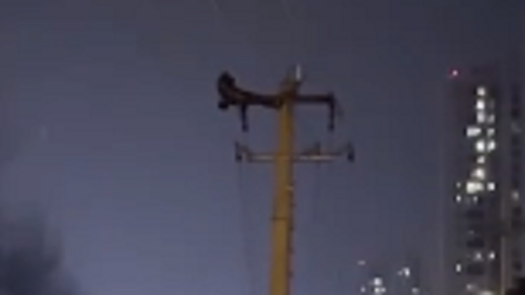 當地一名男子爬上電線桿頂端。（圖／翻攝自微博）