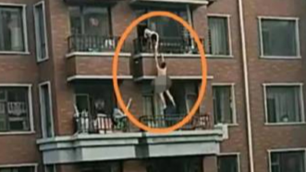 裸體男子吊掛大樓圍牆。（圖／翻攝自微博）