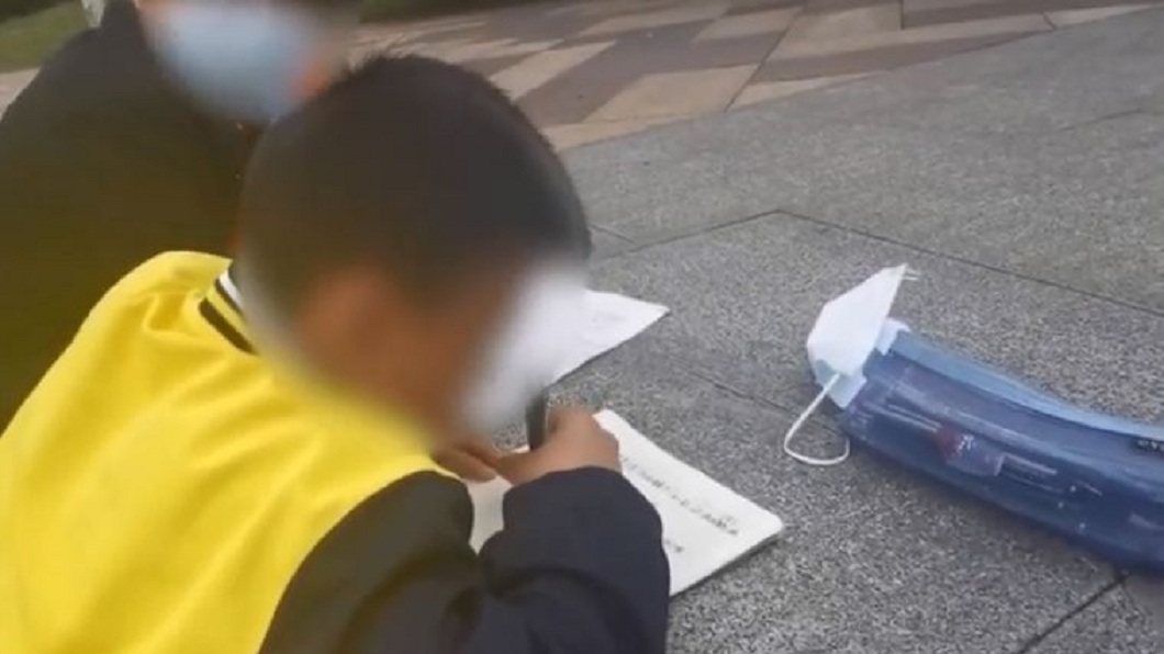 大陸貴陽市日前有民眾目擊2名小學生趴跪在階梯寫作業。（圖／翻攝自YouTube）