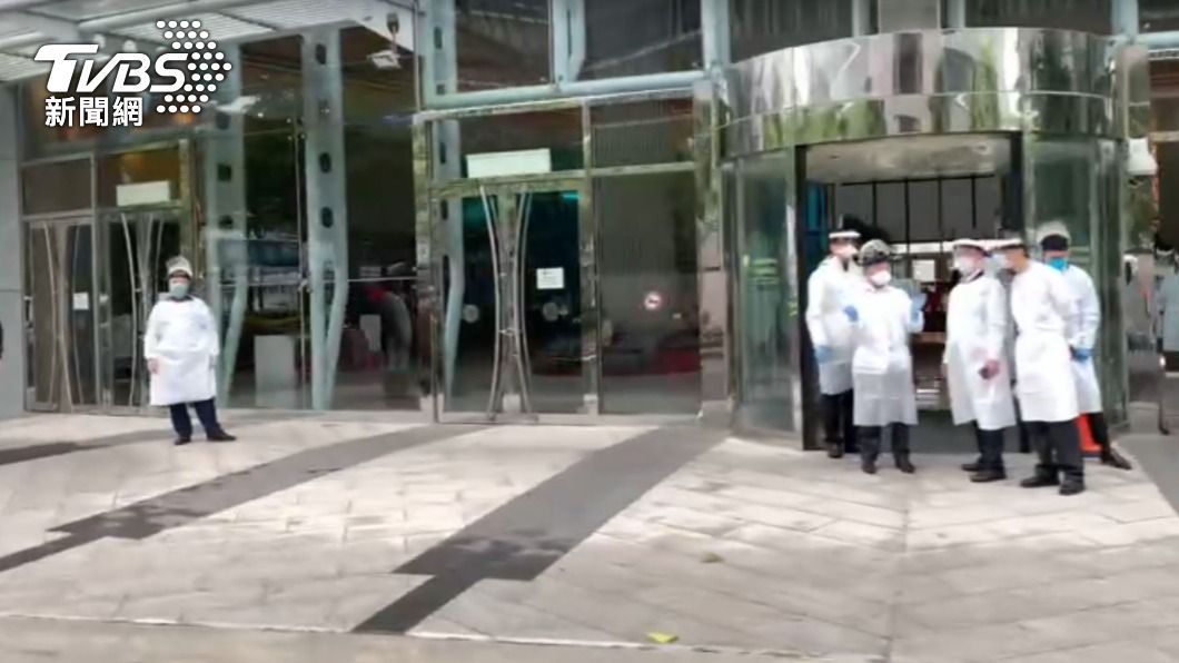 諾富特飯店外畫面，醫護人員都穿防護衣等待。（圖／TVBS）