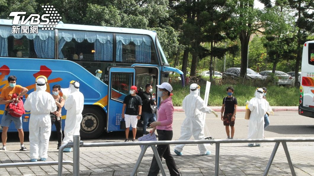移工搭乘巴士抵南科篩檢站，在工作人員引導下進行各項程序。（圖／中央社）
