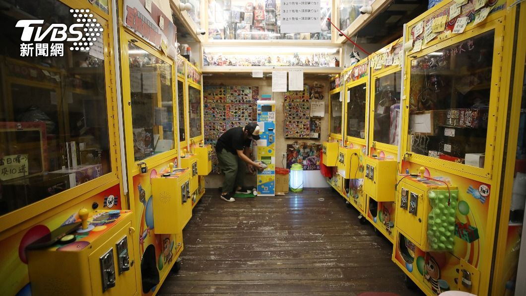 圖為娃娃機店場主在店內做清潔。（圖／中央社）