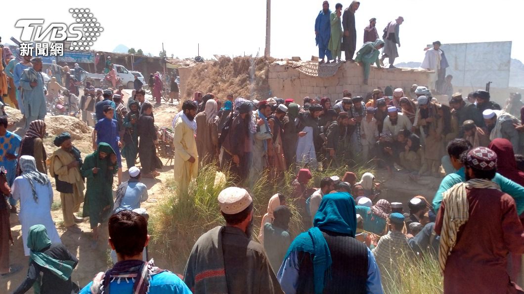 塔利班份子及阿富汗人民圍觀在駁火中喪命的政府軍士兵。（圖／達志影像美聯社） 塔利班勢力推進　美情報：90天內恐拿下阿富汗首都
