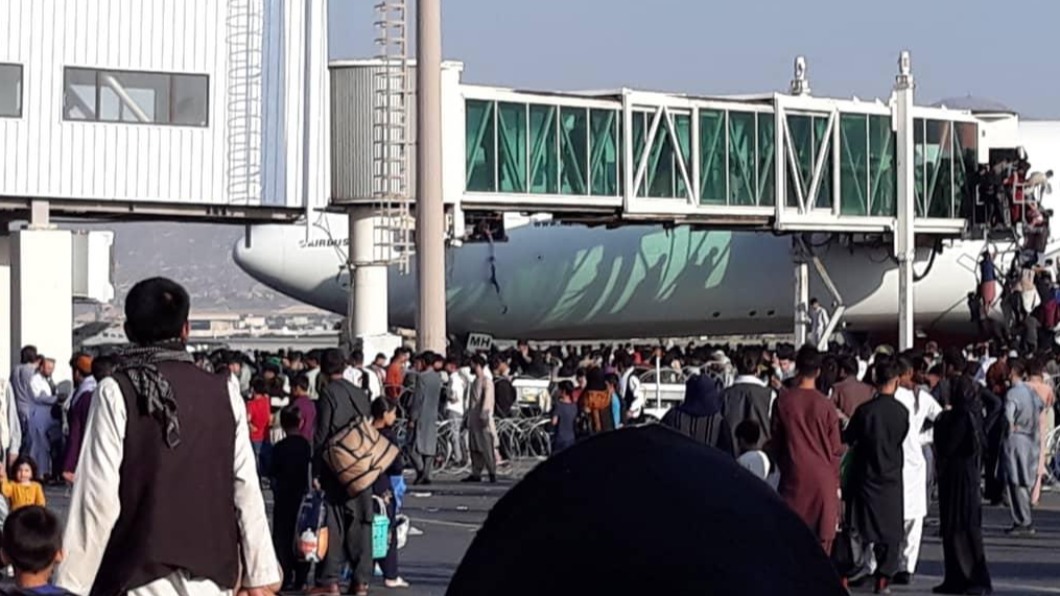民眾攀爬上登機門，示圖闖入飛機內。（圖／翻攝自 Rajesh Sinha 推特 @rajeshsinhaLive） 喀布爾機場驚險畫面曝光！平民失控攀空橋　美軍對空開火
