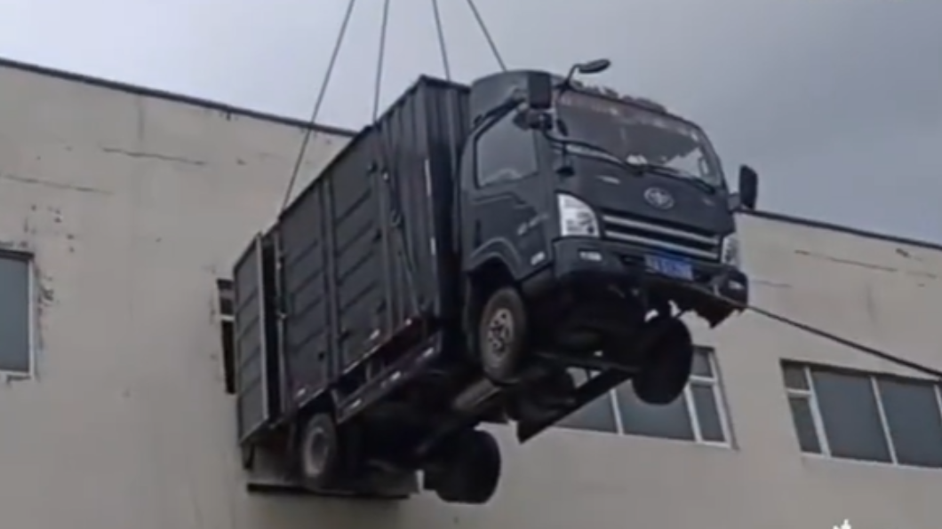 男子用吊車將貨車吊至3樓窗口卸貨。（圖／翻攝自河南電視台都市頻道）