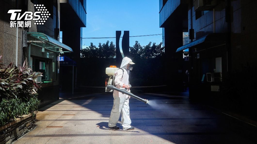圖為清潔人員穿防護衣噴灑消毒，防堵疫情擴散。（圖／中央社）